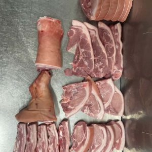 A quarter of a pig butchered and presented on a bench.